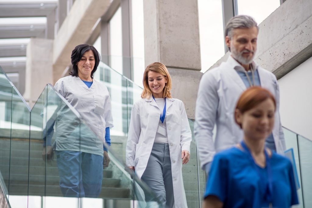 Group of doctors walking down stairs on medical conference, talking.